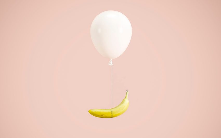 Photo of a Yellow Banana Hanging on a White Balloon