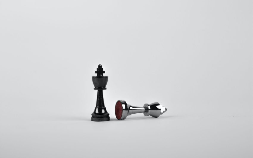 Two Silver Chess Pieces on White Surface